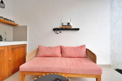 a couch with a pink cushion in a room at Bright, Airy & Private, your 2BR Bali Escape in Seminyak