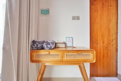 a wooden table in a room with a curtain at Bright, Airy & Private, your 2BR Bali Escape in Seminyak