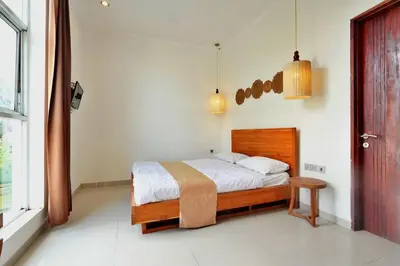 a bedroom with a bed in a room with a window at NR Villa, 2 Bedroom Villa Kerobokan in Seminyak