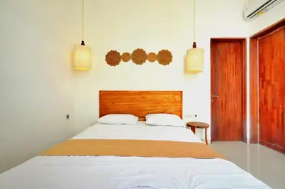 a bedroom with a large bed with two white pillows at NR Villa, 2 Bedroom Villa Kerobokan in Seminyak