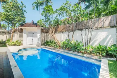 a swimming pool in a backyard with a fence at Uma dharma villas 2 in Seminyak