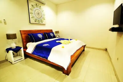 a bedroom with a large bed with blue and white sheets at Villa Dreamz - six bedrooms private villa in Legian