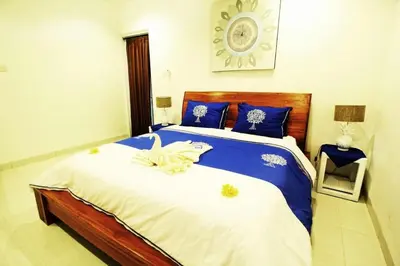 a bedroom with a large bed with blue and white sheets at Villa Dreamz - six bedrooms private villa in Legian