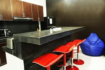 a kitchen with red stools and a counter with a microwave at Villa Dreamz - six bedrooms private villa in Legian