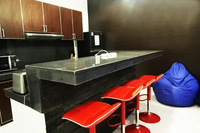 a kitchen with red stools and a counter with a microwave at Villa Dreamz - six bedrooms private villa in Legian