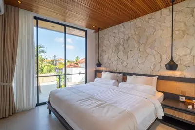 a bedroom with a large bed and a large window at Modern 3BR Villa Seminyak, central location in Seminyak