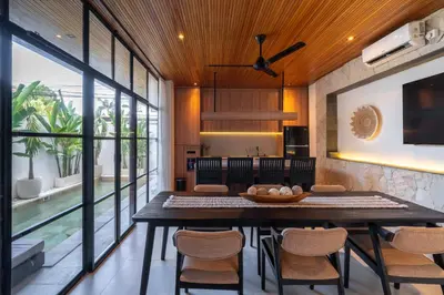 a dining room with a large table and chairs at Modern 3BR Villa Seminyak, central location in Seminyak