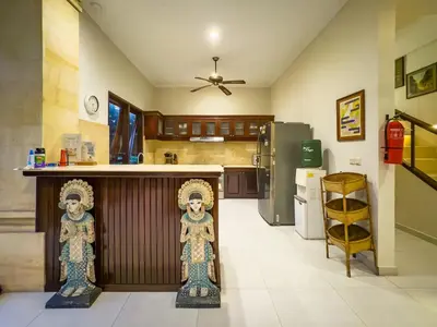 a kitchen with two statues of people standing next to a counter at Arjuna Villa 3 Bedroom Villa Seminyak in Seminyak