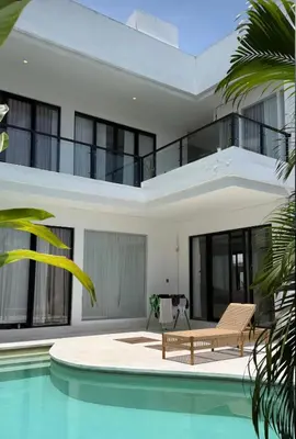 an exterior view of a house with a swimming pool at Sunset room in a shared 4 bedroom villa in Canggu