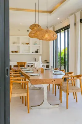 a dining room with a wooden table and chairs at Sunset room in a shared 4 bedroom villa in Canggu