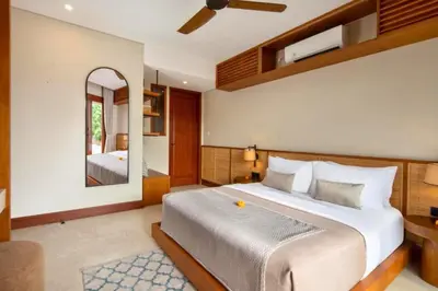 a bedroom with a large bed and a mirror at Annora Cozy 3 BR Private Pool Villa in Canggu