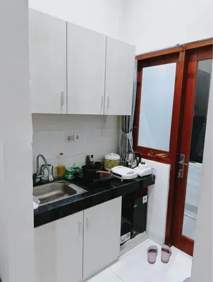 a kitchen with white cabinets and a sink at Room Close to Seminyak - Cozy & Strategic Stay in Seminyak