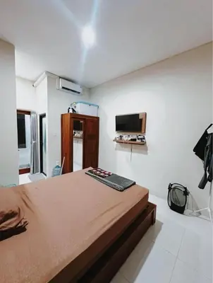a bedroom with a large bed and a flat screen tv at Room Close to Seminyak - Cozy & Strategic Stay in Seminyak