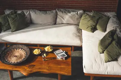 a couch with pillows on top of a coffee table at The Valley Loft in Ngurah Rai International Airport