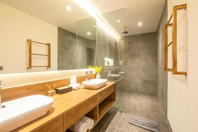 a bathroom with two sinks and a large mirror at Exquisite 6-Bedroom Retreat, Jacuzzi, AC in Canggu
