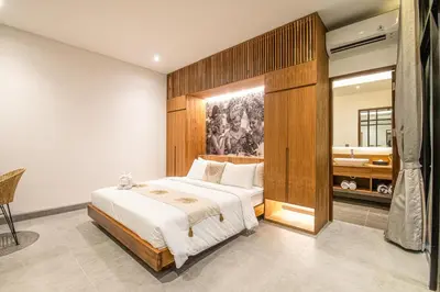 a bedroom with a large bed and a bathroom at Exquisite 6-Bedroom Retreat, Jacuzzi, AC in Canggu