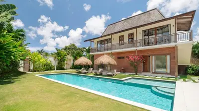 an exterior view of a house with a swimming pool at Alea Estate by Villa Finder in Kerobokan