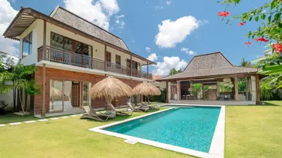 a villa with a swimming pool and a house at Alea Estate by Villa Finder in Kerobokan