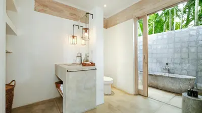 a bathroom with a sink and a bath tub at Alea Estate by Villa Finder in Kerobokan