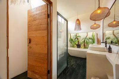 a bathroom with a tub and a sink and a mirror at Villa Mimpikita - Stunning Ibiza-Inspired Villa Near Umalas with Private Pool in Kerobokan