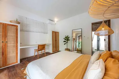 a bedroom with a large bed and a chair at Villa Mimpikita - Stunning Ibiza-Inspired Villa Near Umalas with Private Pool in Kerobokan