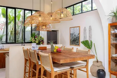 a dining room with a wooden table and chairs at Villa Mimpikita - Stunning Ibiza-Inspired Villa Near Umalas with Private Pool in Kerobokan