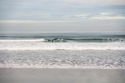a surfer riding a wave in the ocean at Taman Estate by Ekosistem in Seminyak