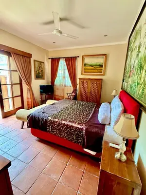 a bedroom with a bed and a table with a lamp at Casa Sophia by Kayana in Sanur