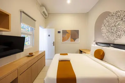 a bedroom with a large bed and a flat screen tv at Cove Nuansa Home in Jimbaran