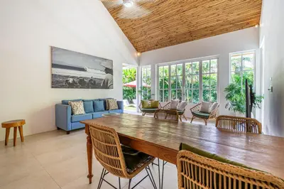 a living room with a large wooden table and chairs at The Oasis Villa in Kerobokan