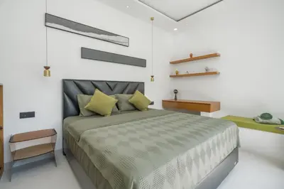 a bedroom with a large bed with yellow pillows at Rosso Verde 2BR Villa near Seminyak in Seminyak