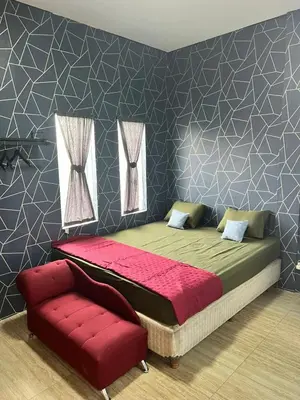 a bedroom with a large bed and a red couch at The Fatul Villa in Ngurah Rai International Airport