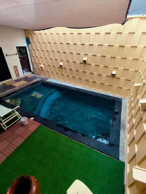an overhead view of a swimming pool with green grass at The Fatul Villa in Ngurah Rai International Airport