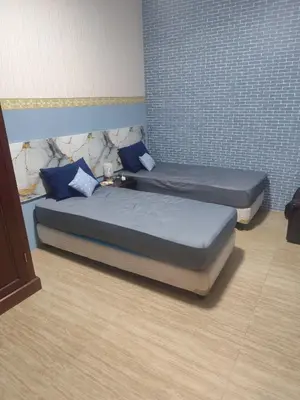 two beds with blue pillows in a room at The Fatul Villa in Ngurah Rai International Airport