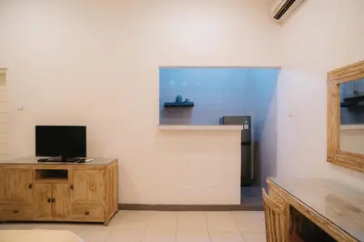 a living room with a tv on a wooden cabinet at Adijaya Room 1 in Seminyak