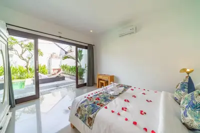 a bedroom with a bed and a large window at Villa Kusuma 2 Seminyak in Seminyak