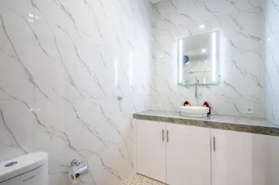 a white bathroom with a sink and a mirror at Luxury minimalist villa The Toy in Kerobokan