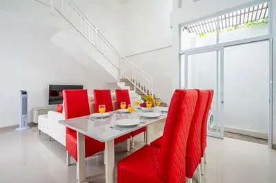 a dining room with a table and red chairs at Luxury minimalist villa The Toy in Kerobokan
