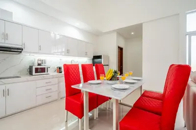 a kitchen with a table and red chairs in a kitchen at Luxury minimalist villa The Toy in Kerobokan