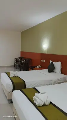 a hotel room with two beds with white towels at Puri dibia apartment in Kuta