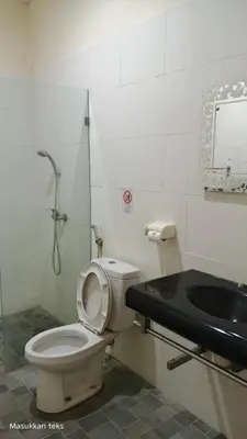 a bathroom with a toilet and a sink at Puri dibia apartment in Kuta