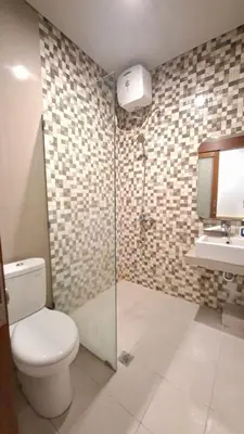 a bathroom with a toilet and a shower and a sink at Mahesa Seminyak in Seminyak