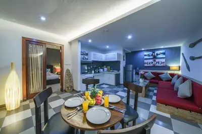 a living room with a table and a red couch at Villa Sun Seminyak in Seminyak