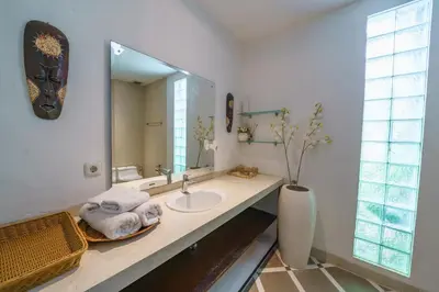 a bathroom with a sink and a large mirror at Villa Sun Seminyak in Seminyak