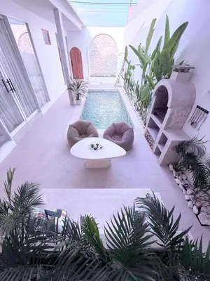 a pool in the middle of a courtyard with a table at Luxury Villa Grand Sanur in Sanur