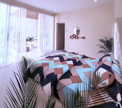 a bedroom with a colorful bed and a plant at Luxury Villa Grand Sanur in Sanur