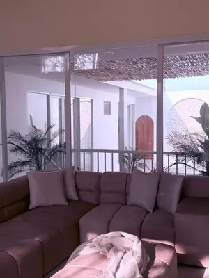 a couch in a living room with a large window at Luxury Villa Grand Sanur in Sanur