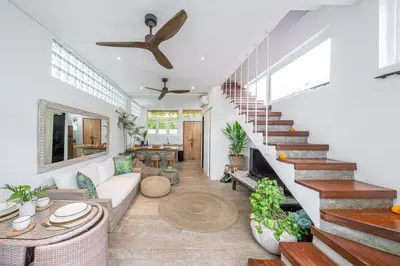 a living room with a white couch and stairs at Villa 888 Tropical Heart - 1BR Pool Villa Seminyak in Seminyak