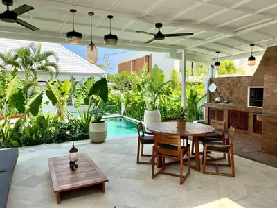 a patio with a table and chairs and a pool at 3BR Luxury Retreat Umalas with Pool - Villa Theo in Canggu