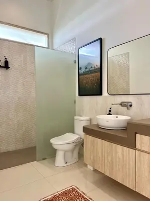 a bathroom with a toilet and a sink and a mirror at 3BR Luxury Retreat Umalas with Pool - Villa Theo in Canggu
